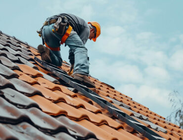 Roofing contractor installing tile roofing on a residential home in Tempe, Arizona, showcasing expert craftsmanship and safety gear.