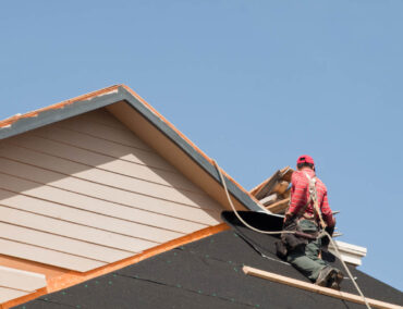 Roofer installing roofing materials on a residential home in Anthem, AZ, demonstrating high-quality craftsmanship and expertise in roofing services.