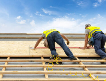 Roofing contractors installing plywood sheathing on a residential roof, showcasing expert craftsmanship in Chandler, AZ.