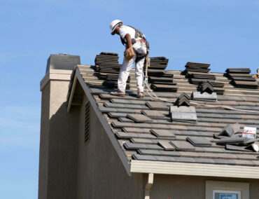 Roofing contractor installing asphalt shingles on a residential roof in Gilbert, AZ, showcasing expert craftsmanship and attention to detail.