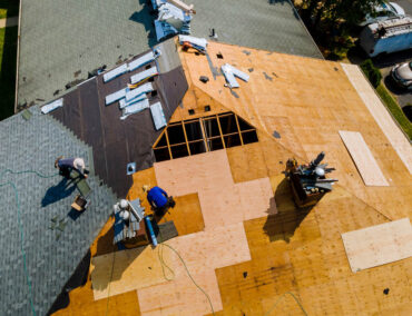 Roof replacement in progress on a Peoria home, featuring workers installing new materials on a sloped roof, demonstrating Ironclad Roofing's commitment to quality craftsmanship and timely service.