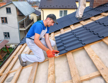 Roofing contractor installing metal roofing on a residential home in Prescott, showcasing craftsmanship and attention to detail in roof replacement services.