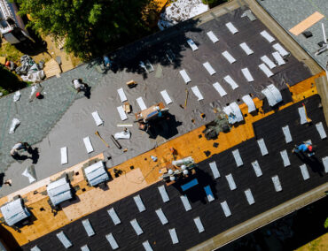 Roofing installation in progress with workers applying materials on a residential roof in Queen Creek, showcasing asphalt shingles and underlayment for efficient roof replacement.