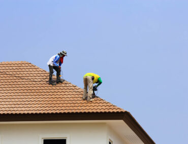 Roofing professionals installing tile roofing on a residential home in Queen Creek, showcasing expert craftsmanship and attention to detail.