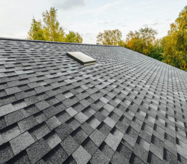 Asphalt shingle roof with skylight, featuring a textured pattern, suitable for Scottsdale's climate, emphasizing quality roofing services offered by Ironclad Roofing.