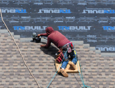 Roofing contractor installing asphalt shingles on a residential roof in Tempe, showcasing expert craftsmanship and quality materials for durable roofing solutions.