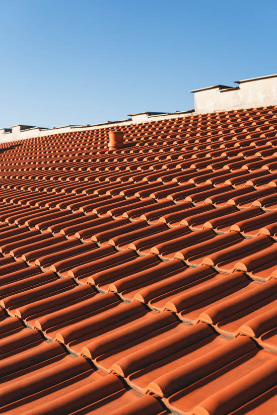 Tile roofing installation showcasing clay tiles under a clear blue sky, emphasizing durability and style for Arizona's climate.